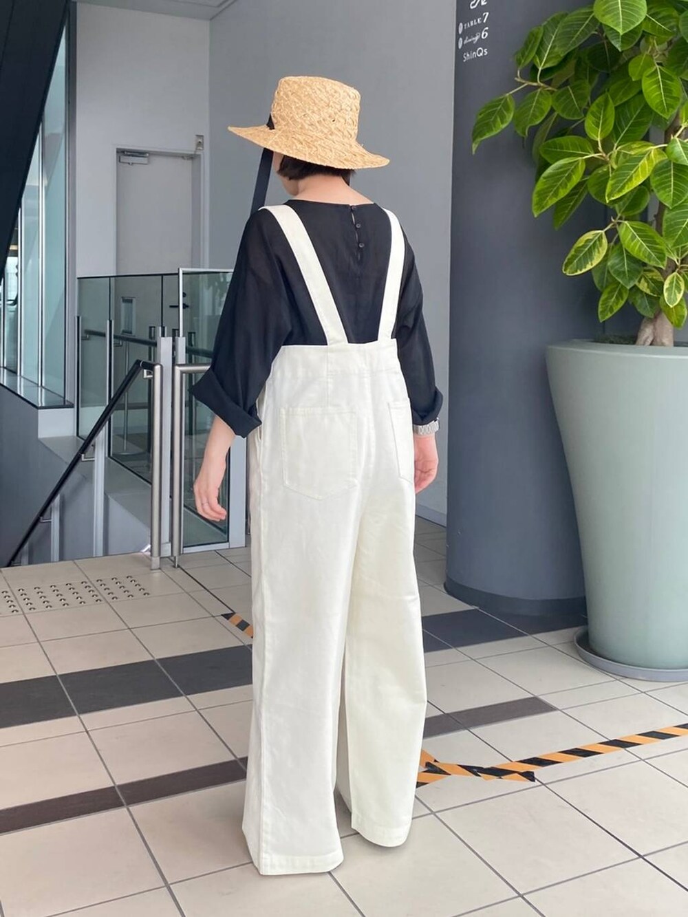 ホワイト系のデニムパンツ、グレー系のTシャツ/カットソー、ベージュ系のハットを着用したレディースの春コーディネートの3枚目の写真