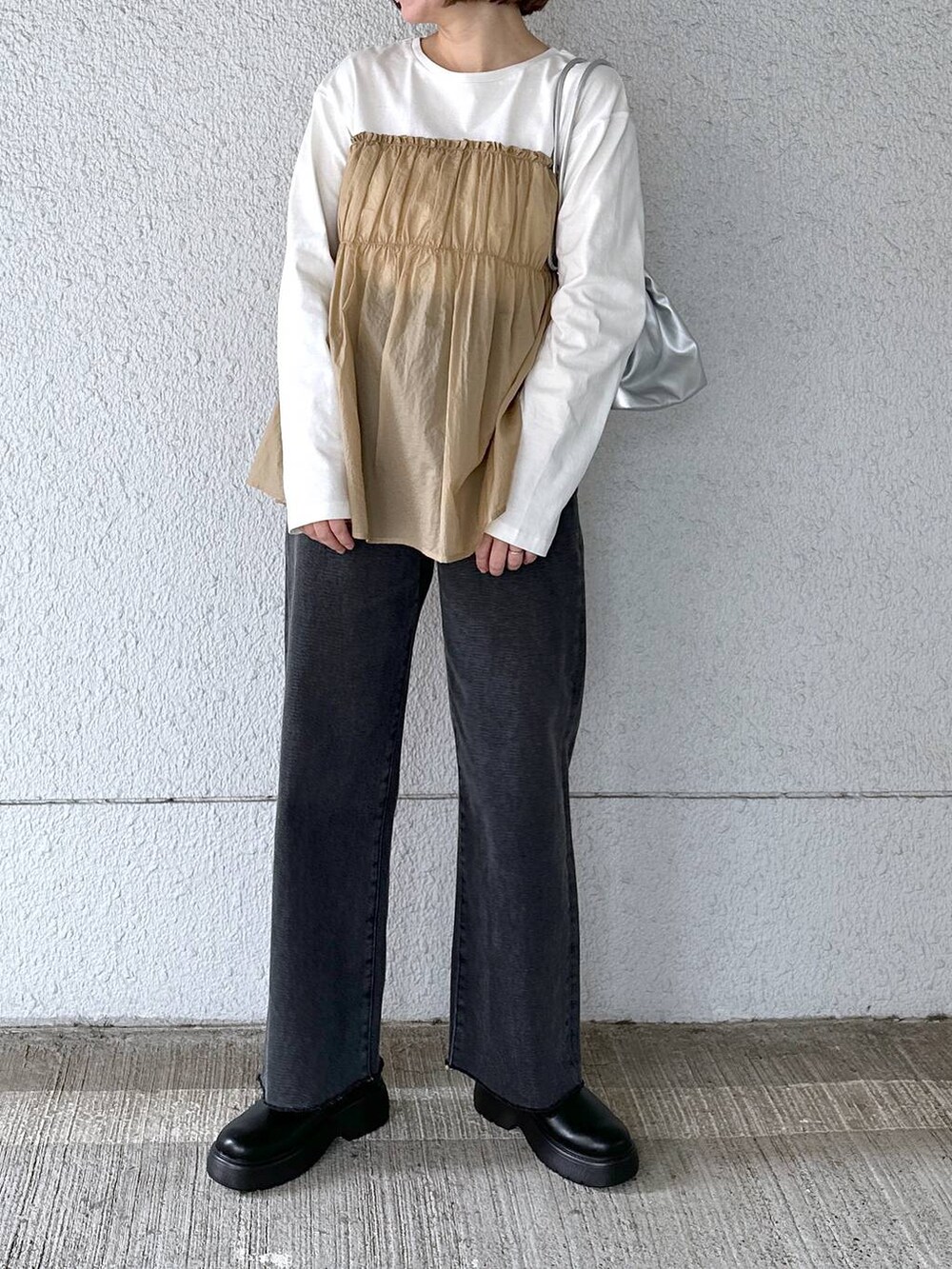 ブラック系のデニムパンツ、ベージュ系のTシャツ/カットソーを着用したレディースの春コーディネートの2枚目の写真