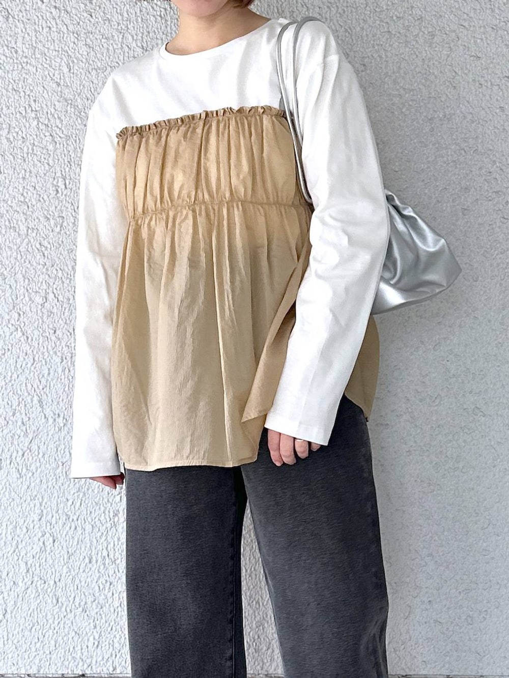 ブラック系のデニムパンツ、ベージュ系のTシャツ/カットソーを着用したレディースの春コーディネートの3枚目の写真