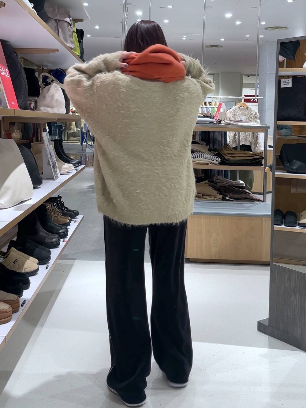 ベージュ系のカーディガン/ボレロ、ブラック系のその他パンツ、オレンジ系のストール/ショールを着用したレディースの冬コーディネートの4枚目の写真