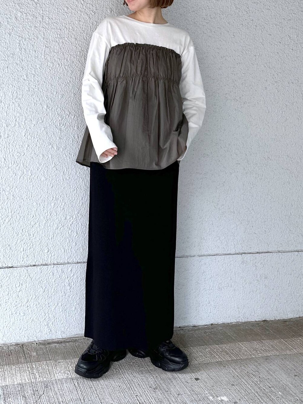 グリーン系のTシャツ/カットソー、ブラック系のスカートを着用したレディースの春コーディネートの2枚目の写真