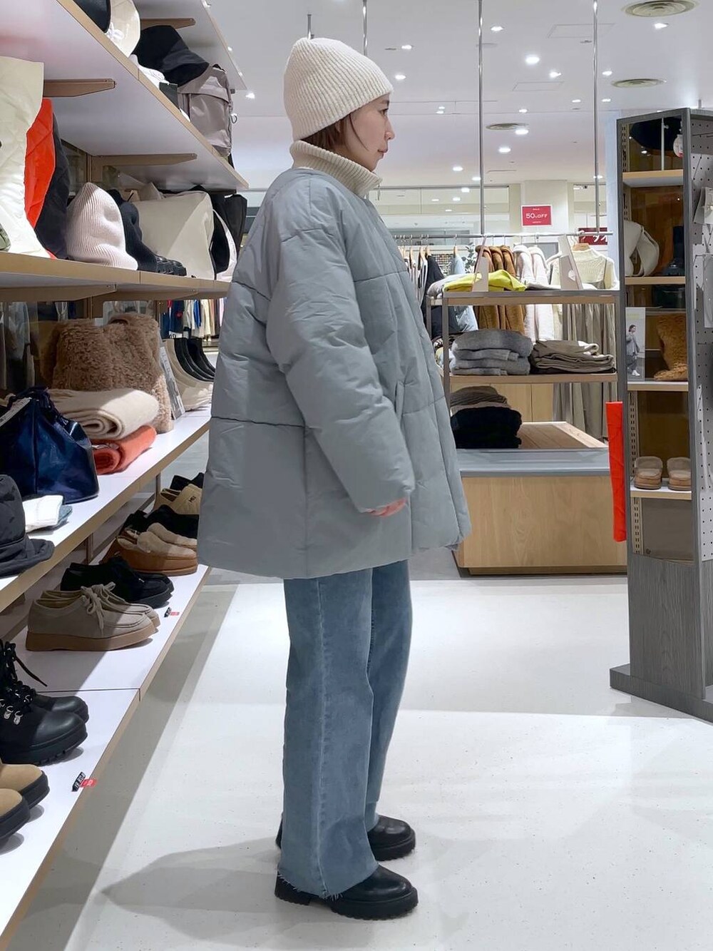 ホワイト系のニット/セーター、ブルー系のその他アウター、ブルー系のデニムパンツを着用したレディースの冬コーディネートの3枚目の写真