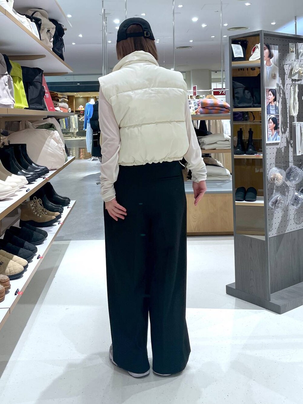 ホワイト系のTシャツ/カットソー、ホワイト系のベスト、ブラック系のスラックスを着用したレディースの冬コーディネートの5枚目の写真