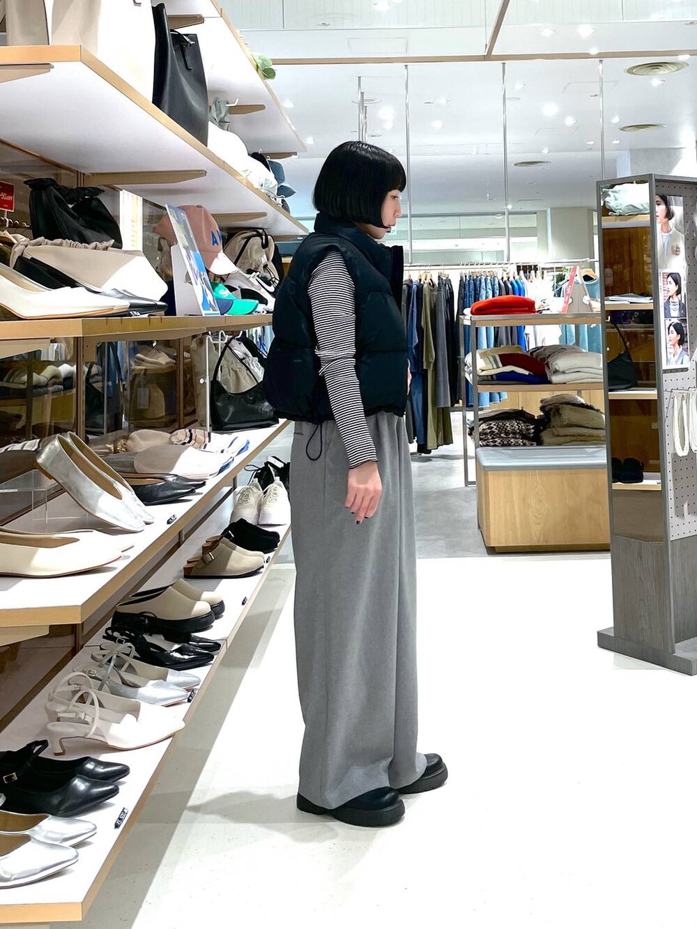 ブラック系のベスト、ホワイト系のTシャツ/カットソー、グレー系のスラックスを着用したレディースの冬コーディネートの3枚目の写真