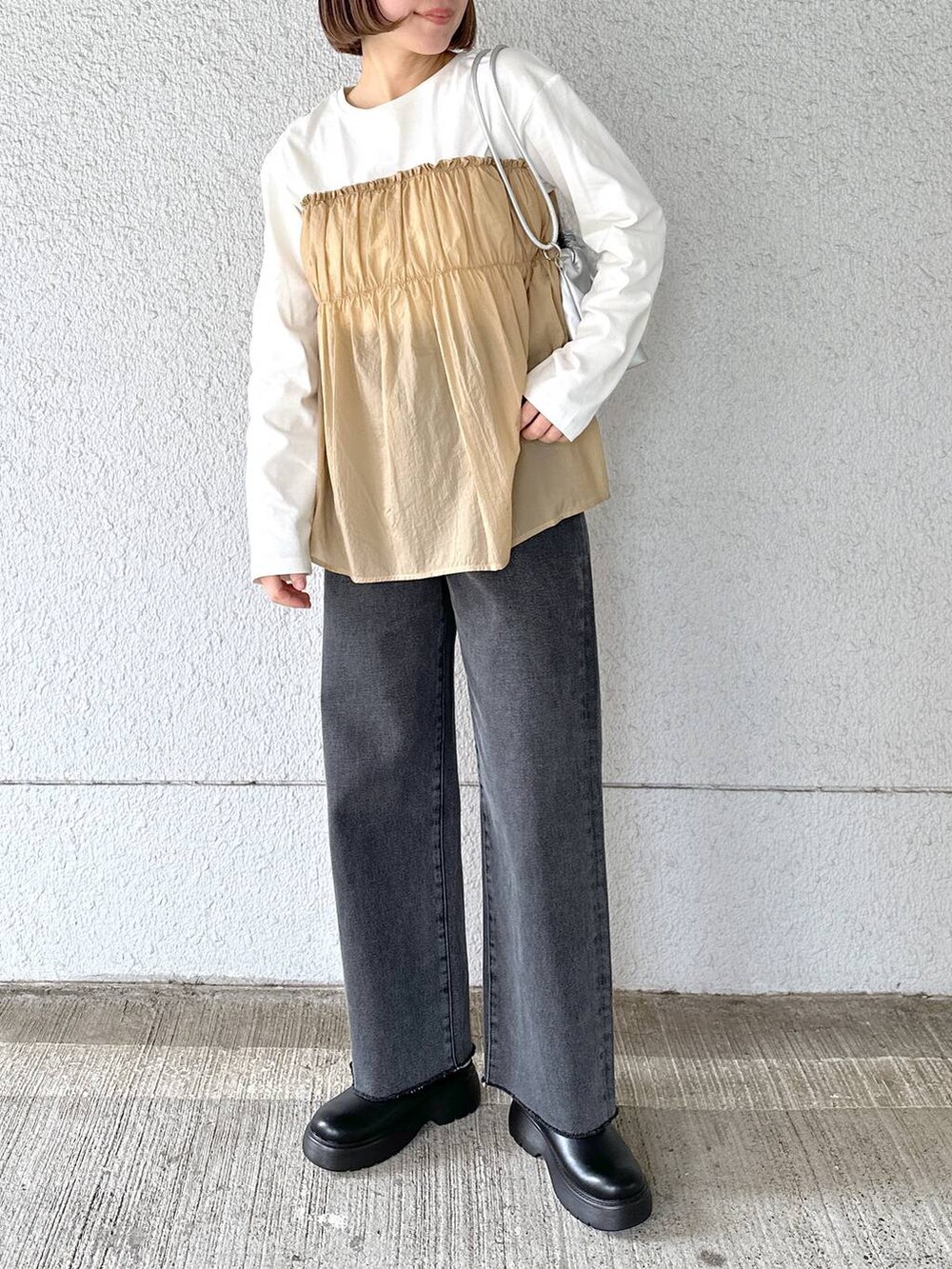 ブラック系のデニムパンツ、ベージュ系のTシャツ/カットソーを着用したレディースの春コーディネートの4枚目の写真