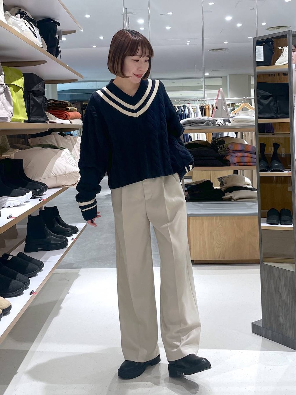 ブルー系のニット/セーター、ベージュ系のスラックスを着用したレディースの冬コーディネートの2枚目の写真