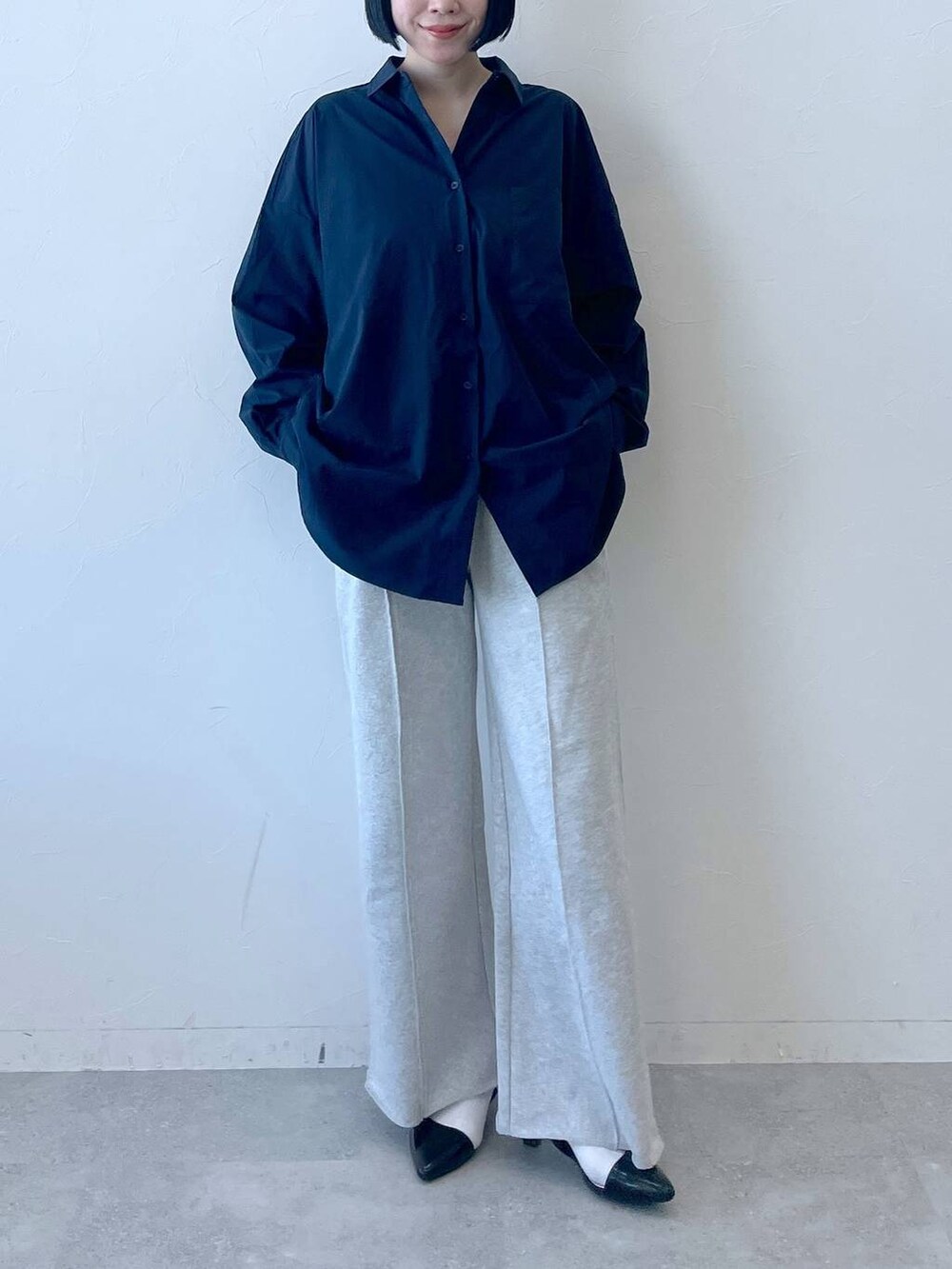 ブルー系のシャツ/ブラウス、ブラック系のパンプス、グレー系のスウェットパンツを着用したレディースの春コーディネートの2枚目の写真