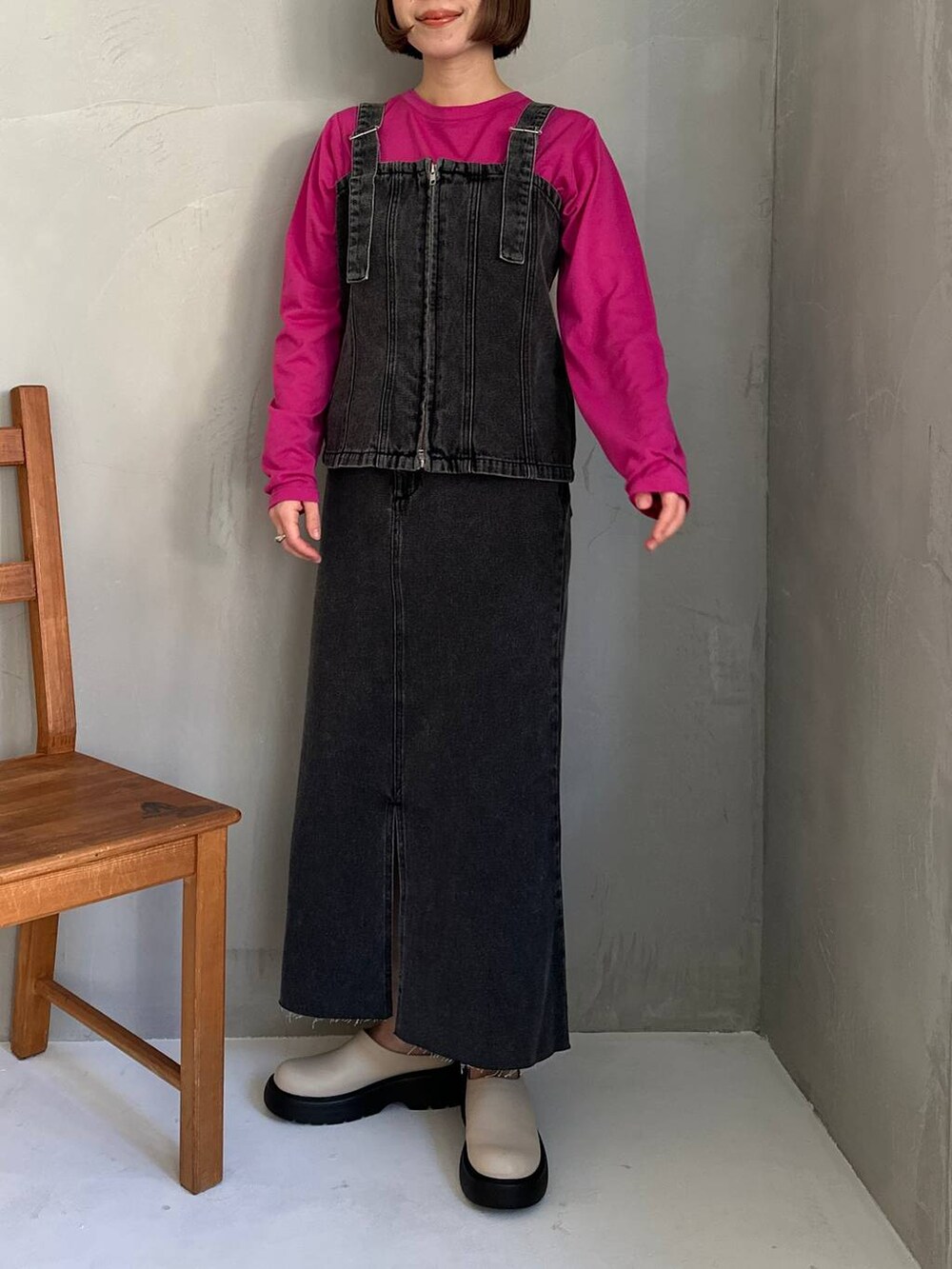 ブラック系のベスト、ブラック系のスカート、ピンク系のTシャツ/カットソーを着用したレディースの冬コーディネートの2枚目の写真