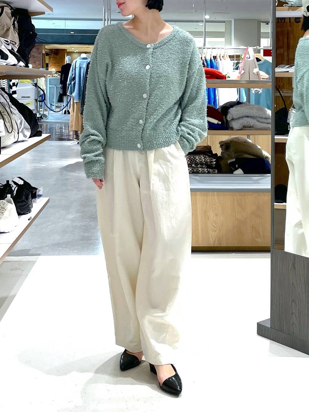 グリーン系のカーディガン/ボレロ、ホワイト系のその他パンツ、ブラック系のパンプスを着用したレディースの冬コーディネートの2枚目の写真