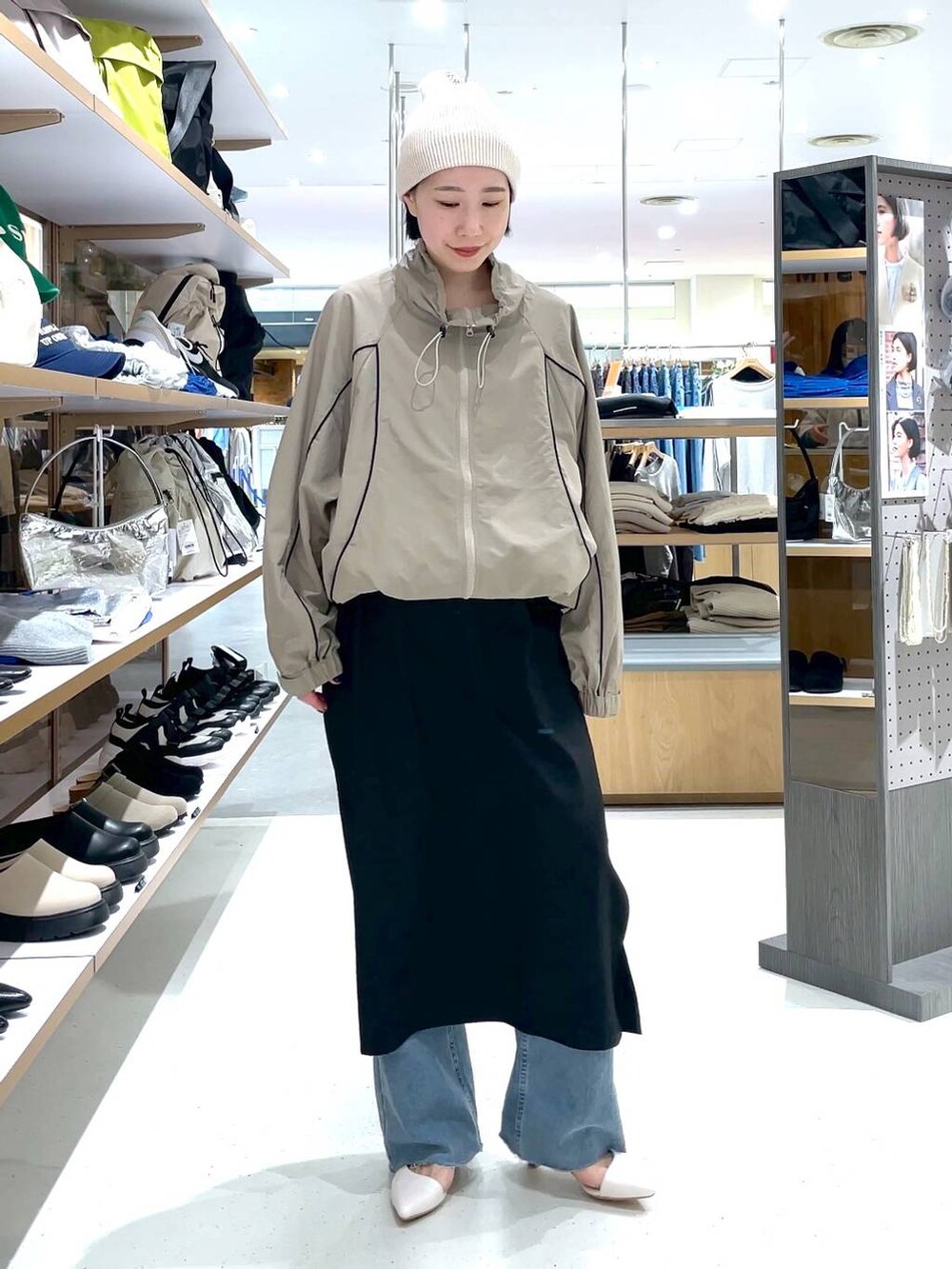 ブラック系のスカート、ブルー系のデニムパンツ、ベージュ系のその他アウターを着用したレディースの冬コーディネートの6枚目の写真