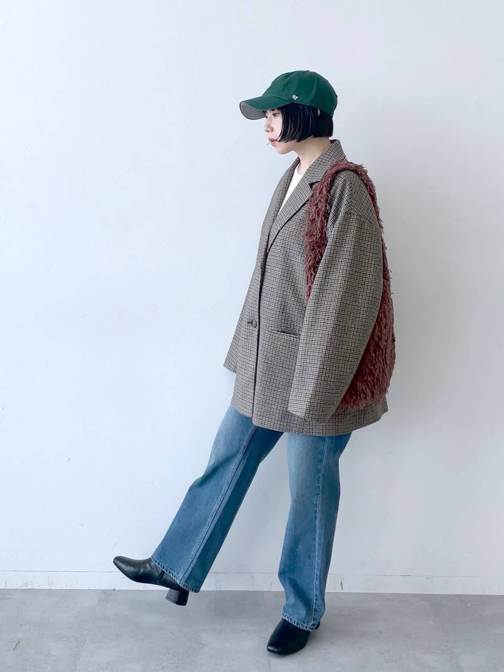 ブラウン系のその他アウター、ブルー系のデニムパンツ、ブラック系のブーツを着用したレディースの秋コーディネートの2枚目の写真
