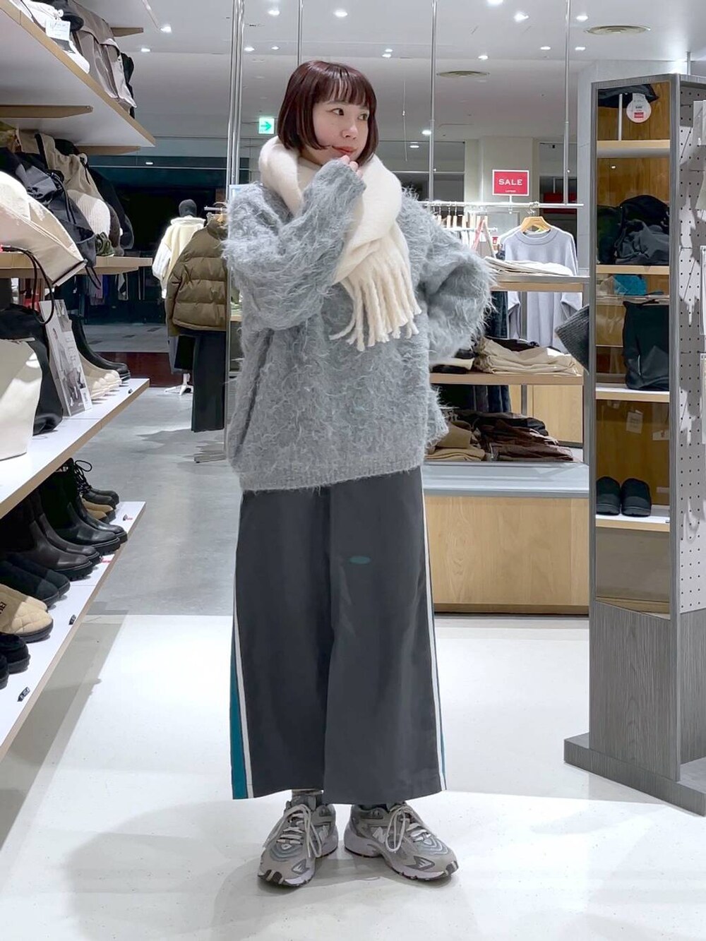 グレー系のカーディガン/ボレロ、グレー系のスカート、ホワイト系のストール/ショールを着用したレディースの冬コーディネートの5枚目の写真