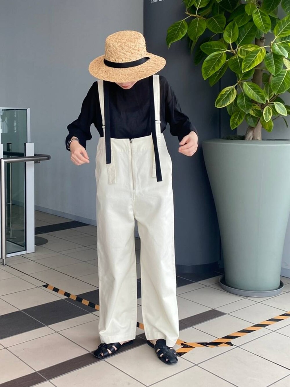 ホワイト系のデニムパンツ、グレー系のTシャツ/カットソー、ベージュ系のハットを着用したレディースの春コーディネートの2枚目の写真