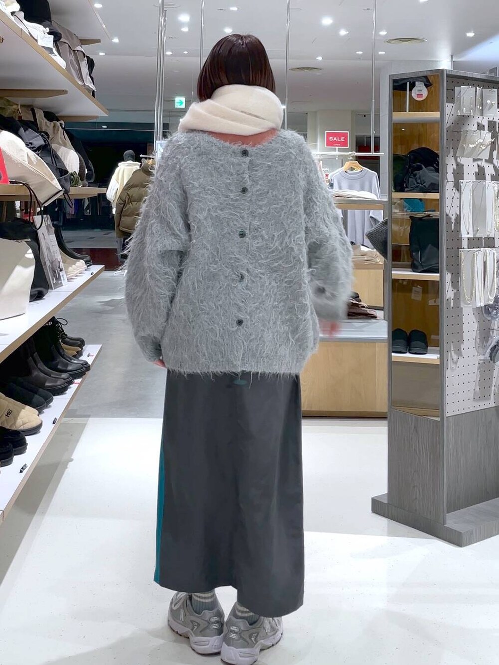 グレー系のカーディガン/ボレロ、グレー系のスカート、ホワイト系のストール/ショールを着用したレディースの冬コーディネートの4枚目の写真