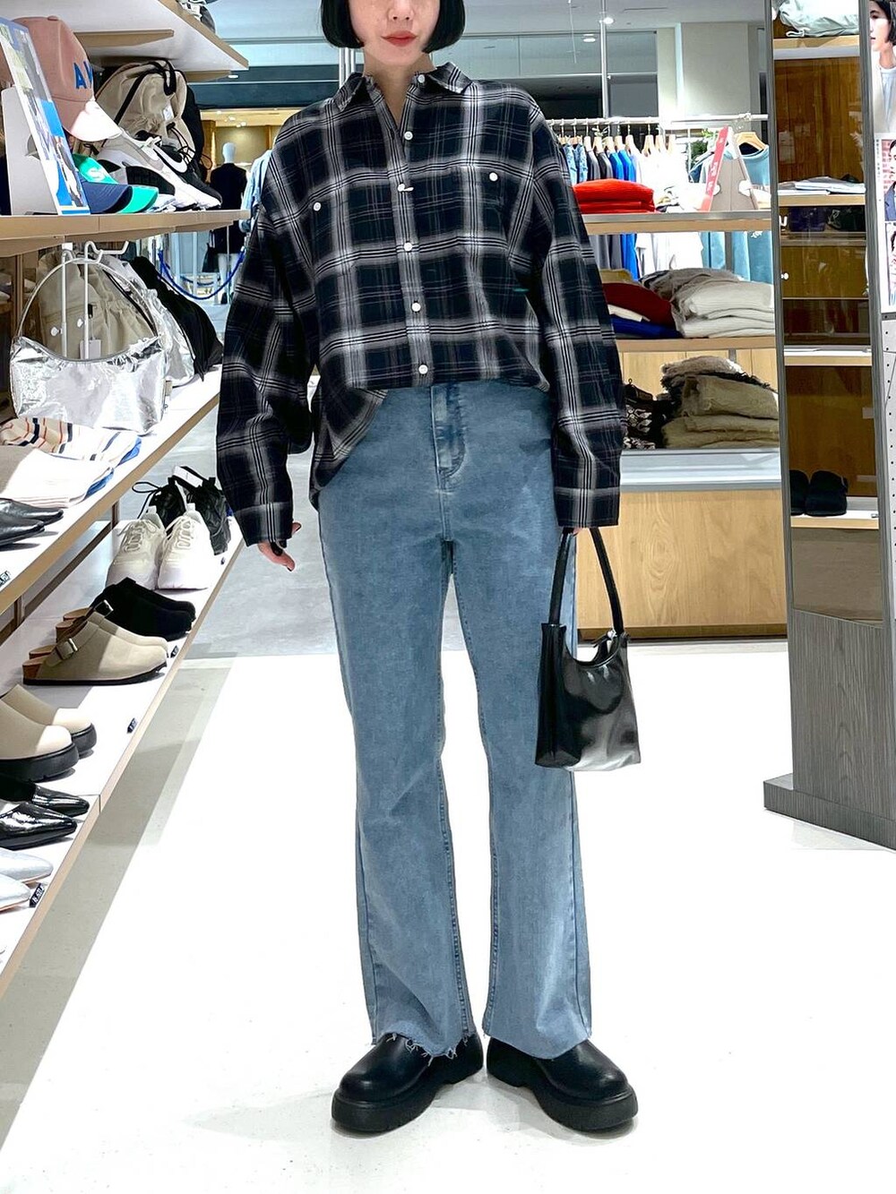 ブラック系のハンドバッグ、ブルー系のデニムパンツ、ブラック系のシャツ/ブラウスを着用したレディースの冬コーディネートの2枚目の写真