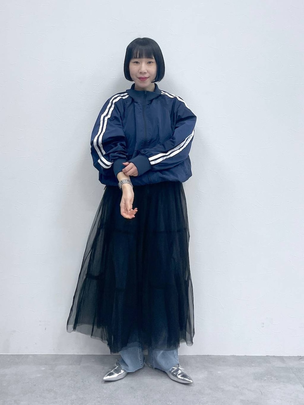 ブラック系のスカート、ブルー系のデニムパンツ、ブルー系のブルゾンを着用したレディースの春コーディネートの5枚目の写真
