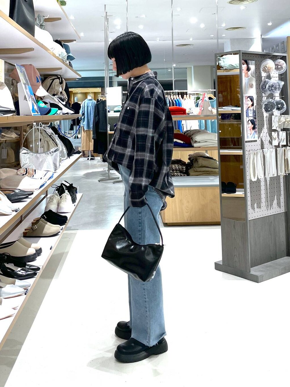 ブラック系のハンドバッグ、ブルー系のデニムパンツ、ブラック系のシャツ/ブラウスを着用したレディースの冬コーディネートの4枚目の写真