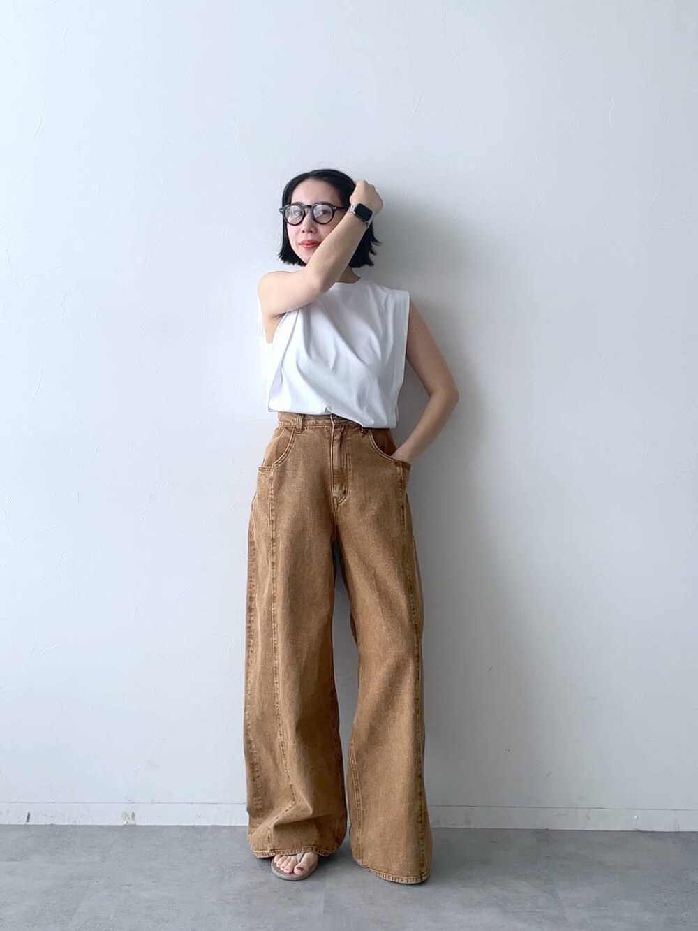 ブラウン系のデニムパンツを着用したレディースの夏コーディネートの2枚目の写真