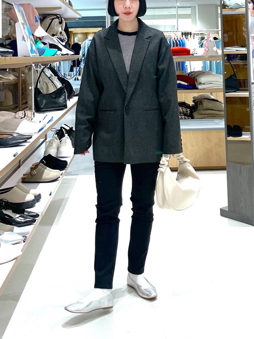 ホワイト系のショルダーバッグ、グレー系のパンプス、ブラック系のその他パンツを着用したレディースの冬コーディネートの2枚目の写真