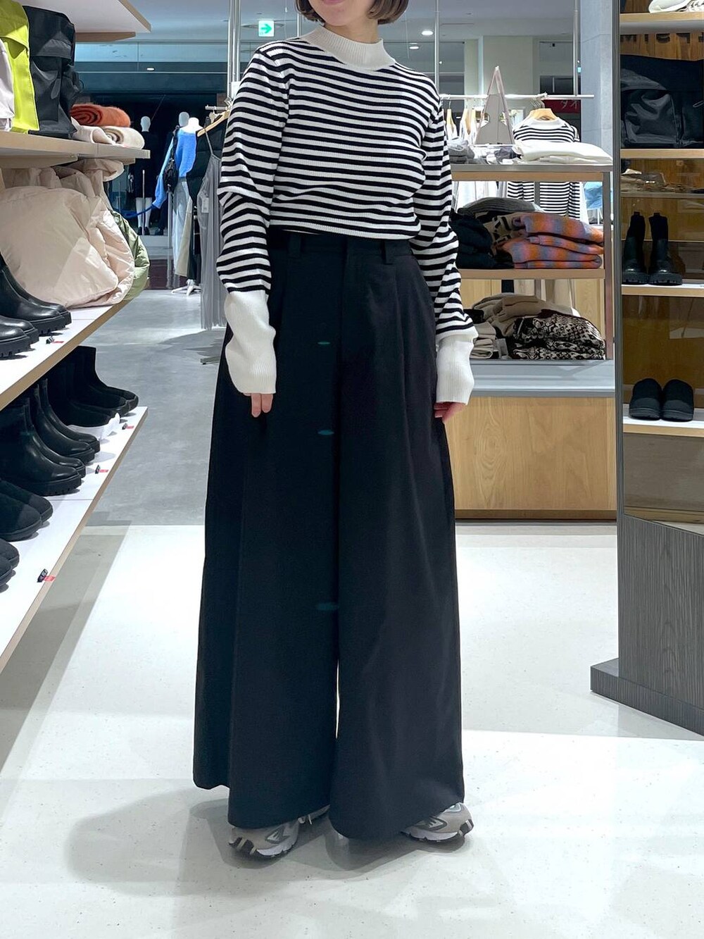 ホワイト系のニット/セーター、ブラック系のチノパンツを着用したレディースの冬コーディネートの4枚目の写真