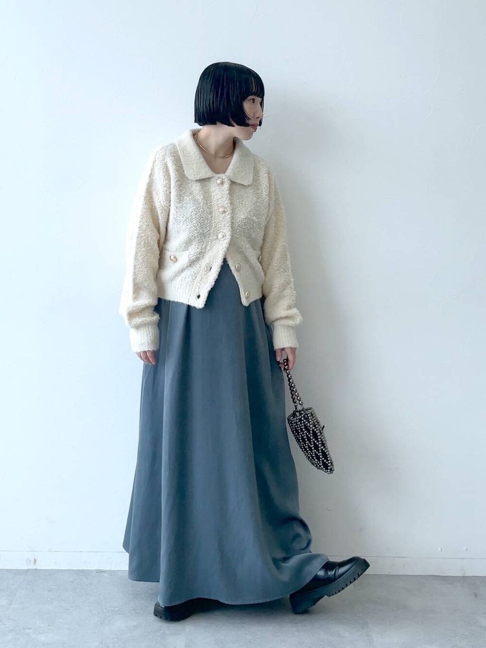 ブラック系のブーツ、ブルー系のワンピース、ホワイト系のカーディガン/ボレロを着用したレディースの秋コーディネートの4枚目の写真