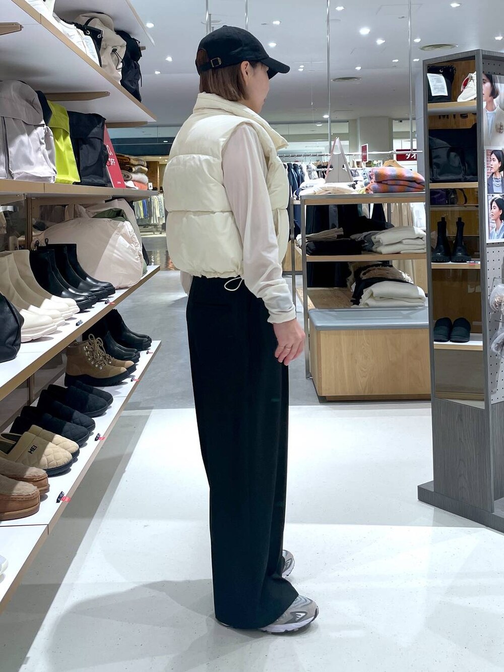 ホワイト系のTシャツ/カットソー、ホワイト系のベスト、ブラック系のスラックスを着用したレディースの冬コーディネートの4枚目の写真