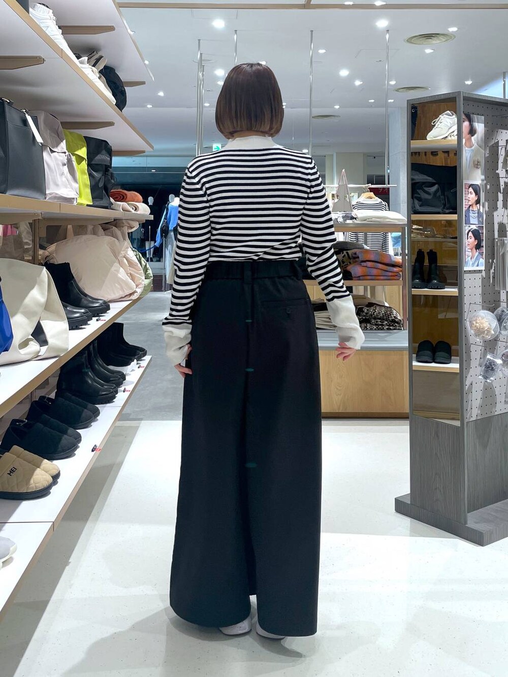 ホワイト系のニット/セーター、ブラック系のチノパンツを着用したレディースの冬コーディネートの3枚目の写真