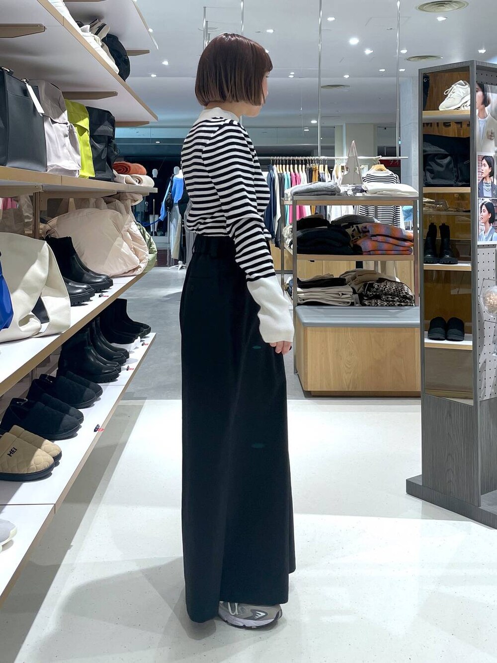 ホワイト系のニット/セーター、ブラック系のチノパンツを着用したレディースの冬コーディネートの2枚目の写真