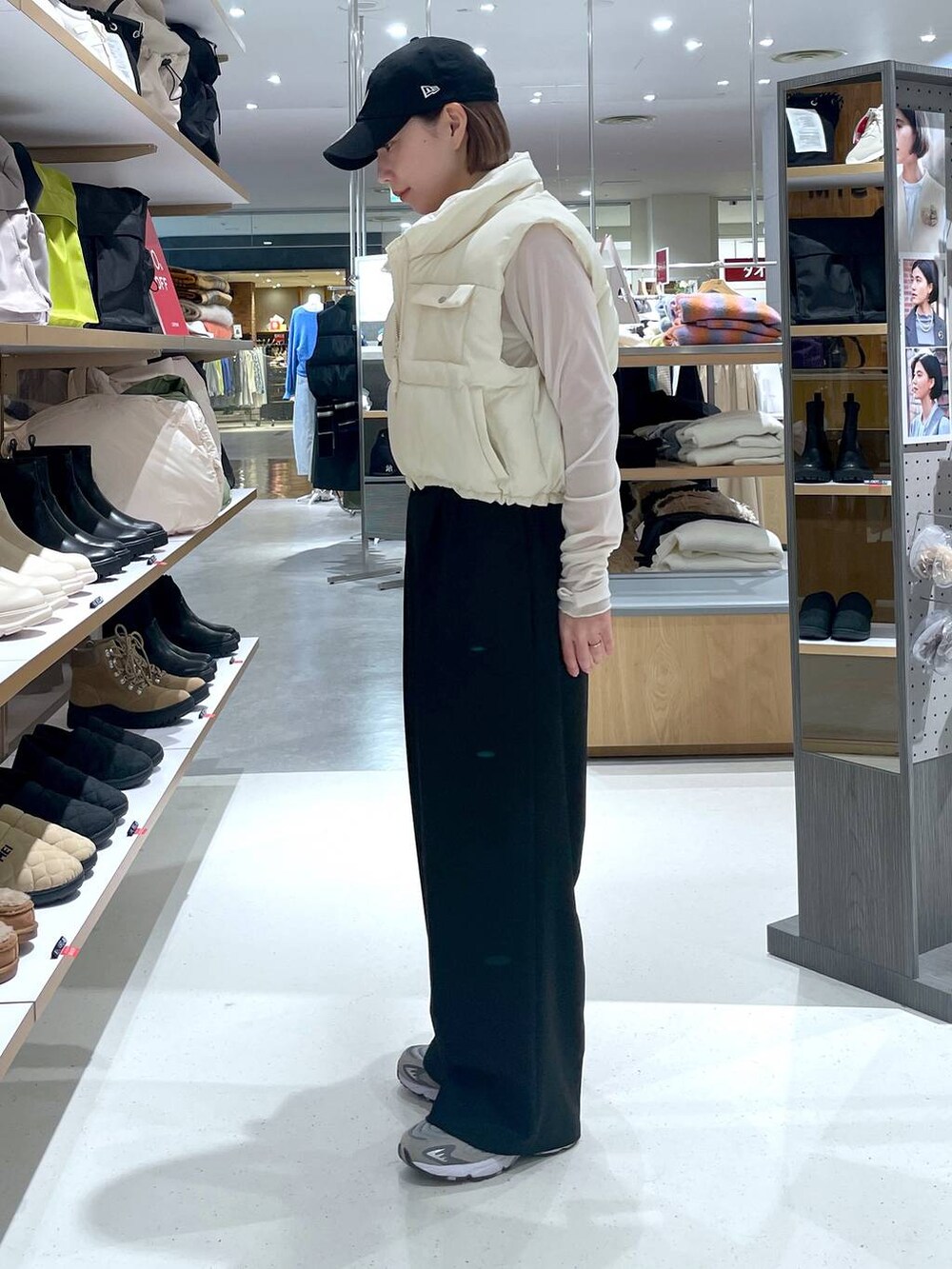 ホワイト系のTシャツ/カットソー、ホワイト系のベスト、ブラック系のスラックスを着用したレディースの冬コーディネートの3枚目の写真