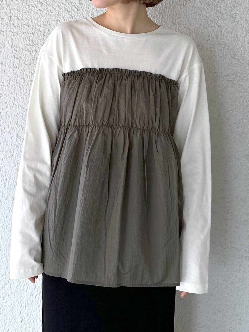 グリーン系のTシャツ/カットソー、ブラック系のスカートを着用したレディースの春コーディネートの3枚目の写真