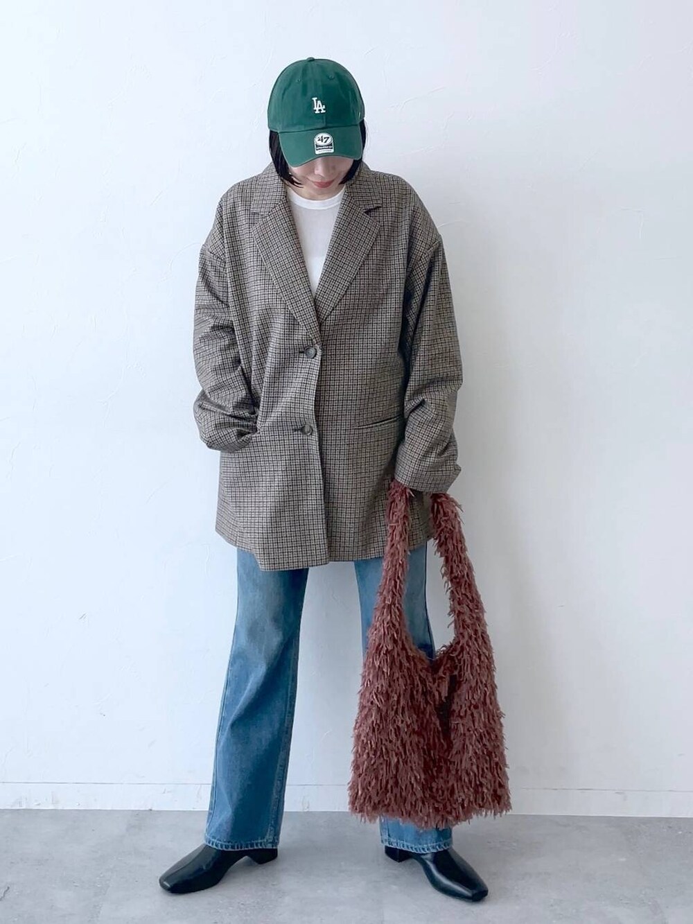 ブラウン系のその他アウター、ブルー系のデニムパンツ、ブラック系のブーツを着用したレディースの秋コーディネートの3枚目の写真