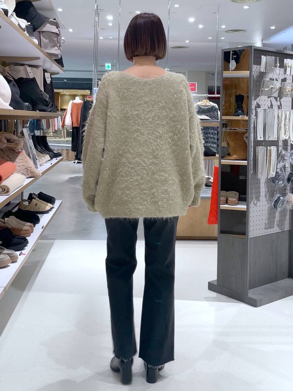 ベージュ系のカーディガン/ボレロ、グレー系のデニムパンツを着用したレディースの冬コーディネートの4枚目の写真