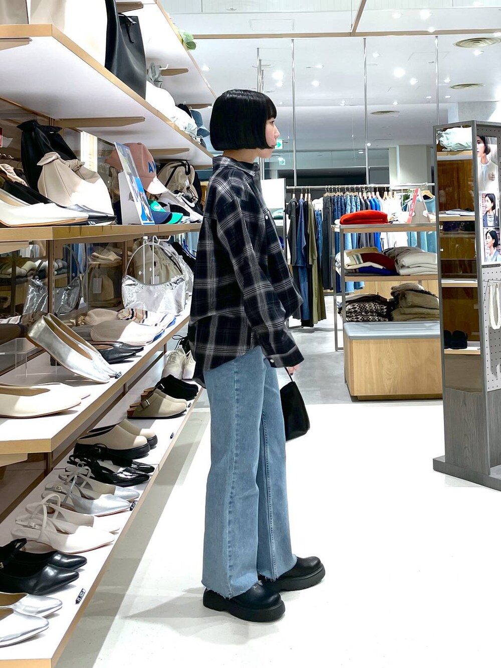 ブラック系のハンドバッグ、ブルー系のデニムパンツ、ブラック系のシャツ/ブラウスを着用したレディースの冬コーディネートの5枚目の写真