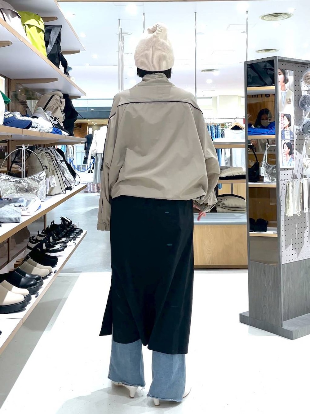 ブラック系のスカート、ブルー系のデニムパンツ、ベージュ系のその他アウターを着用したレディースの冬コーディネートの4枚目の写真