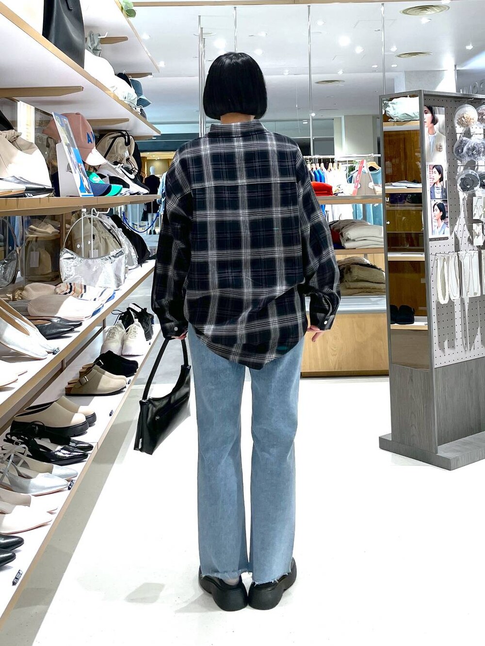 ブラック系のハンドバッグ、ブルー系のデニムパンツ、ブラック系のシャツ/ブラウスを着用したレディースの冬コーディネートの6枚目の写真