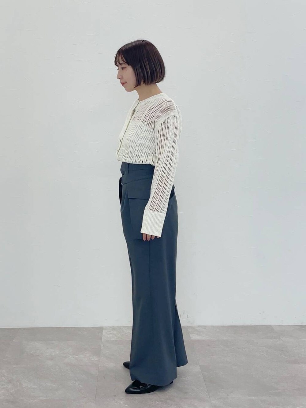 グレー系のその他パンツ、ホワイト系のカーディガン/ボレロを着用したレディースの冬コーディネートの3枚目の写真