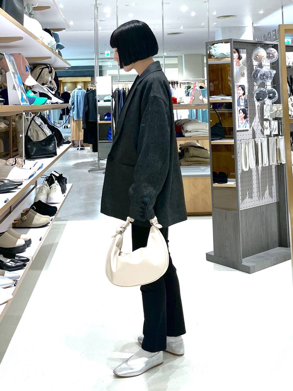 ホワイト系のショルダーバッグ、グレー系のパンプス、ブラック系のその他パンツを着用したレディースの冬コーディネートの3枚目の写真