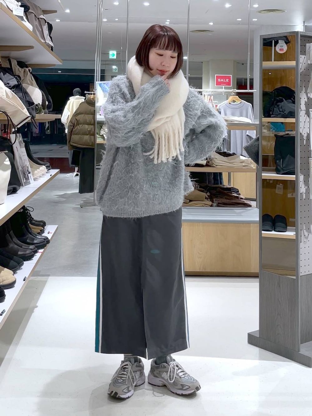 グレー系のカーディガン/ボレロ、グレー系のスカート、ホワイト系のストール/ショールを着用したレディースの冬コーディネートの2枚目の写真