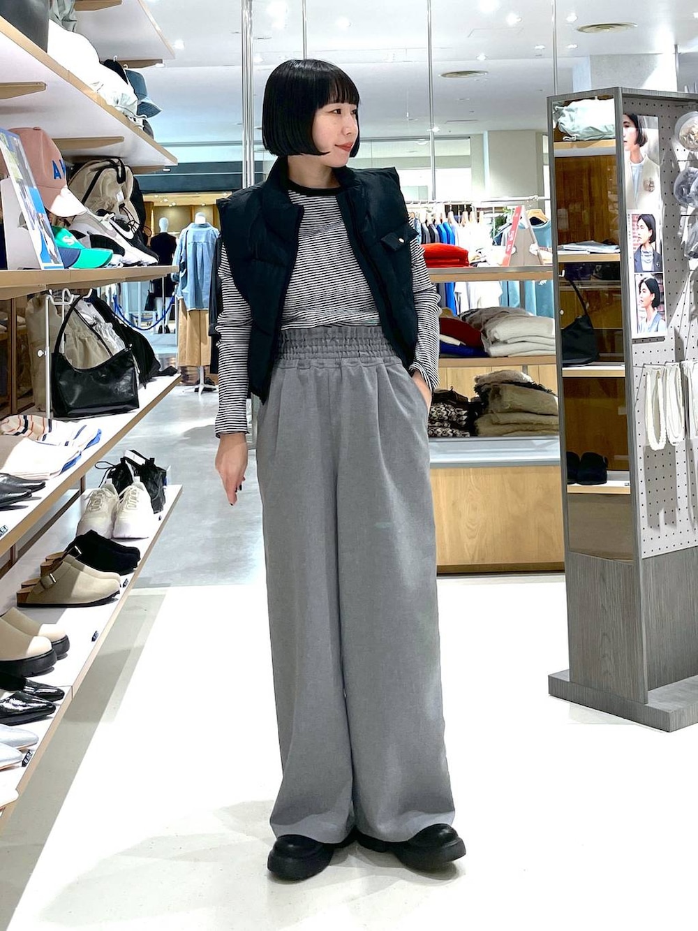 ブラック系のベスト、ホワイト系のTシャツ/カットソー、グレー系のスラックスを着用したレディースの冬コーディネートの5枚目の写真