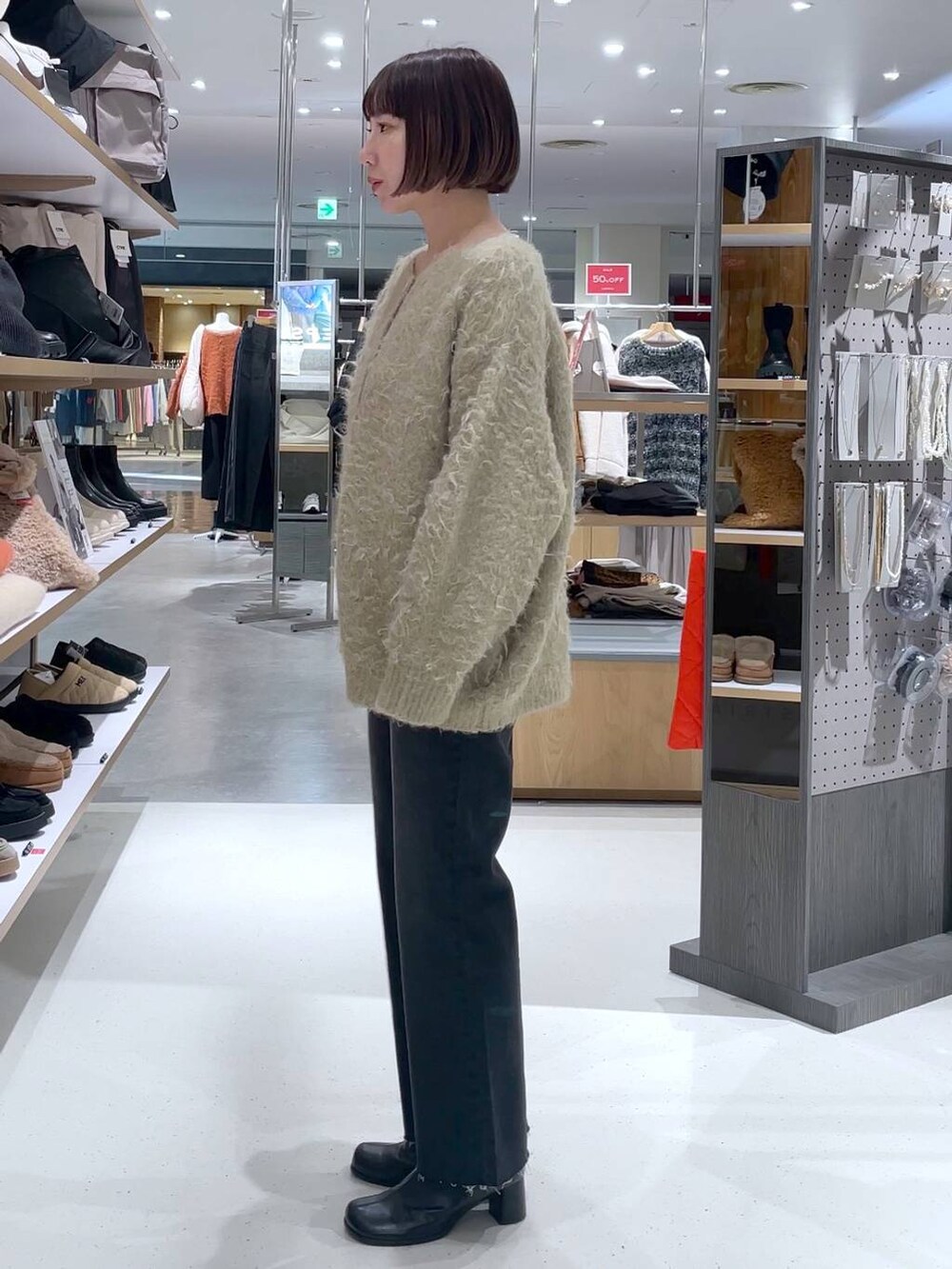 ベージュ系のカーディガン/ボレロ、グレー系のデニムパンツを着用したレディースの冬コーディネートの3枚目の写真