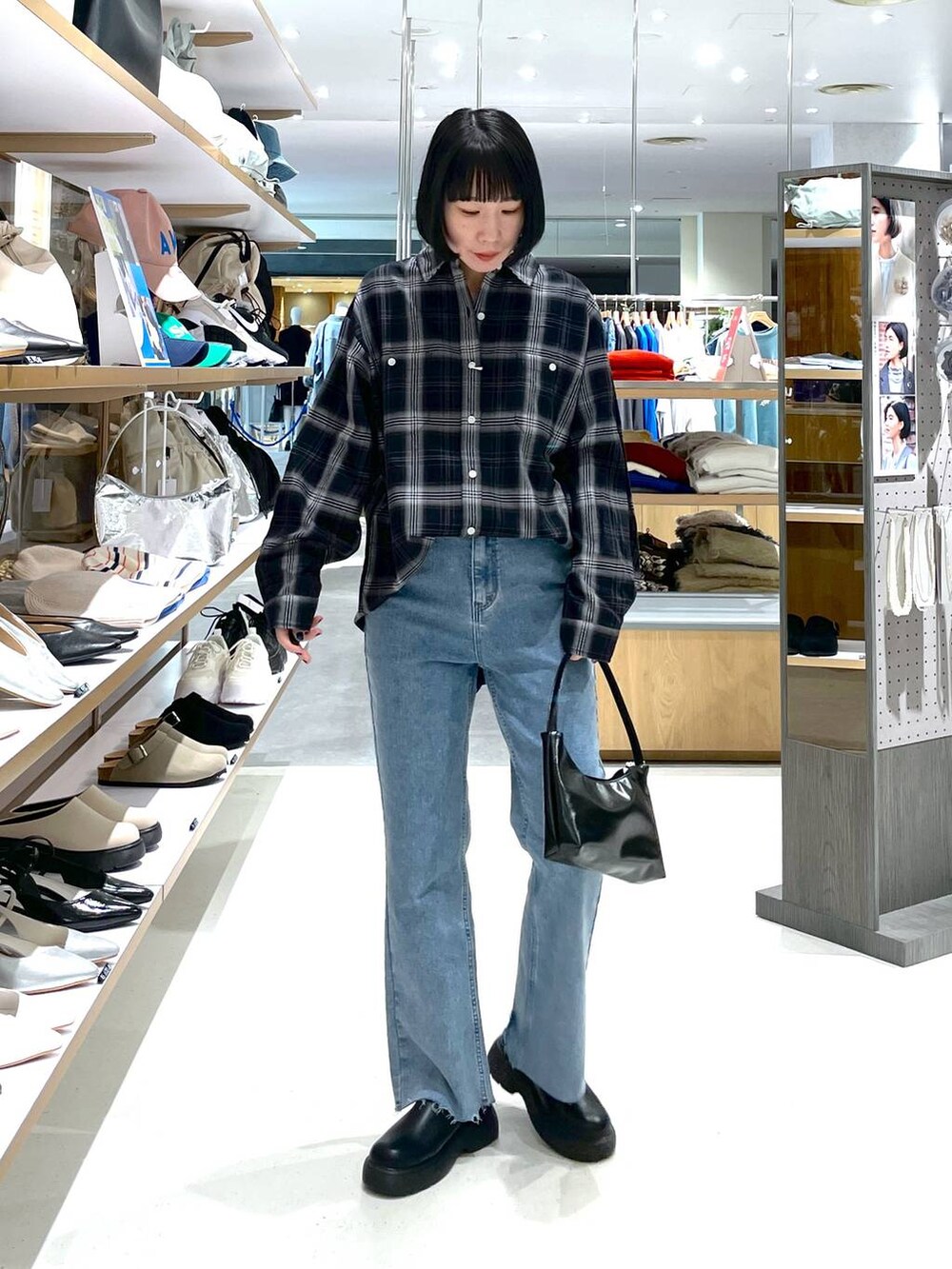 ブラック系のハンドバッグ、ブルー系のデニムパンツ、ブラック系のシャツ/ブラウスを着用したレディースの冬コーディネートの7枚目の写真