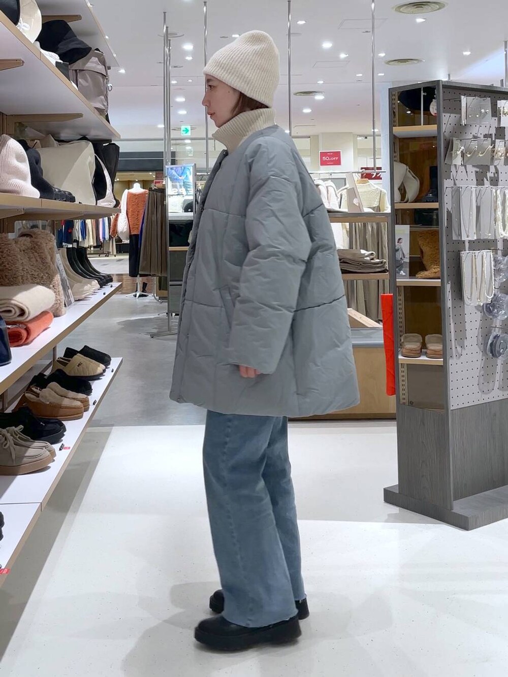 ホワイト系のニット/セーター、ブルー系のその他アウター、ブルー系のデニムパンツを着用したレディースの冬コーディネートの4枚目の写真
