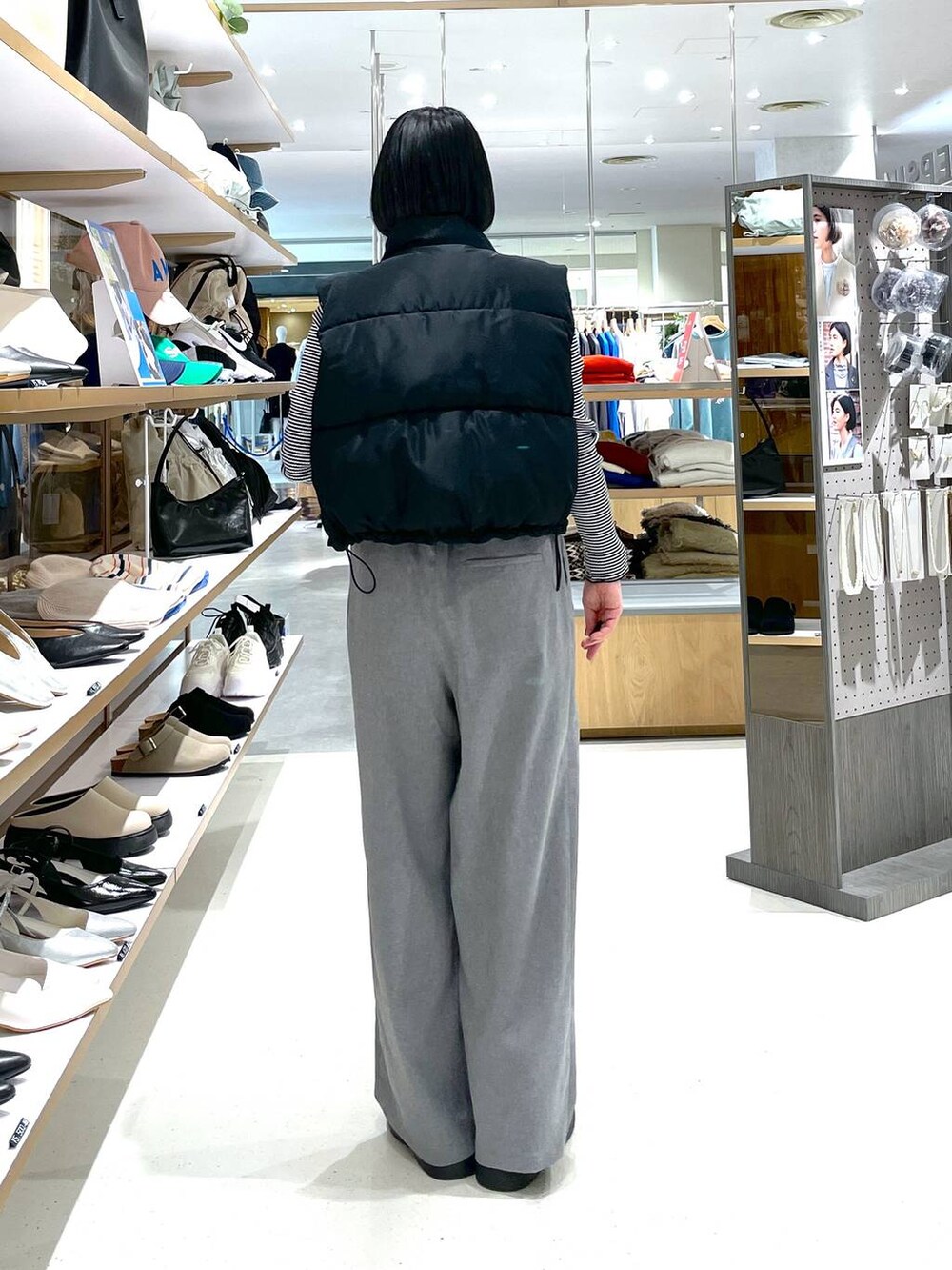 ブラック系のベスト、ホワイト系のTシャツ/カットソー、グレー系のスラックスを着用したレディースの冬コーディネートの4枚目の写真