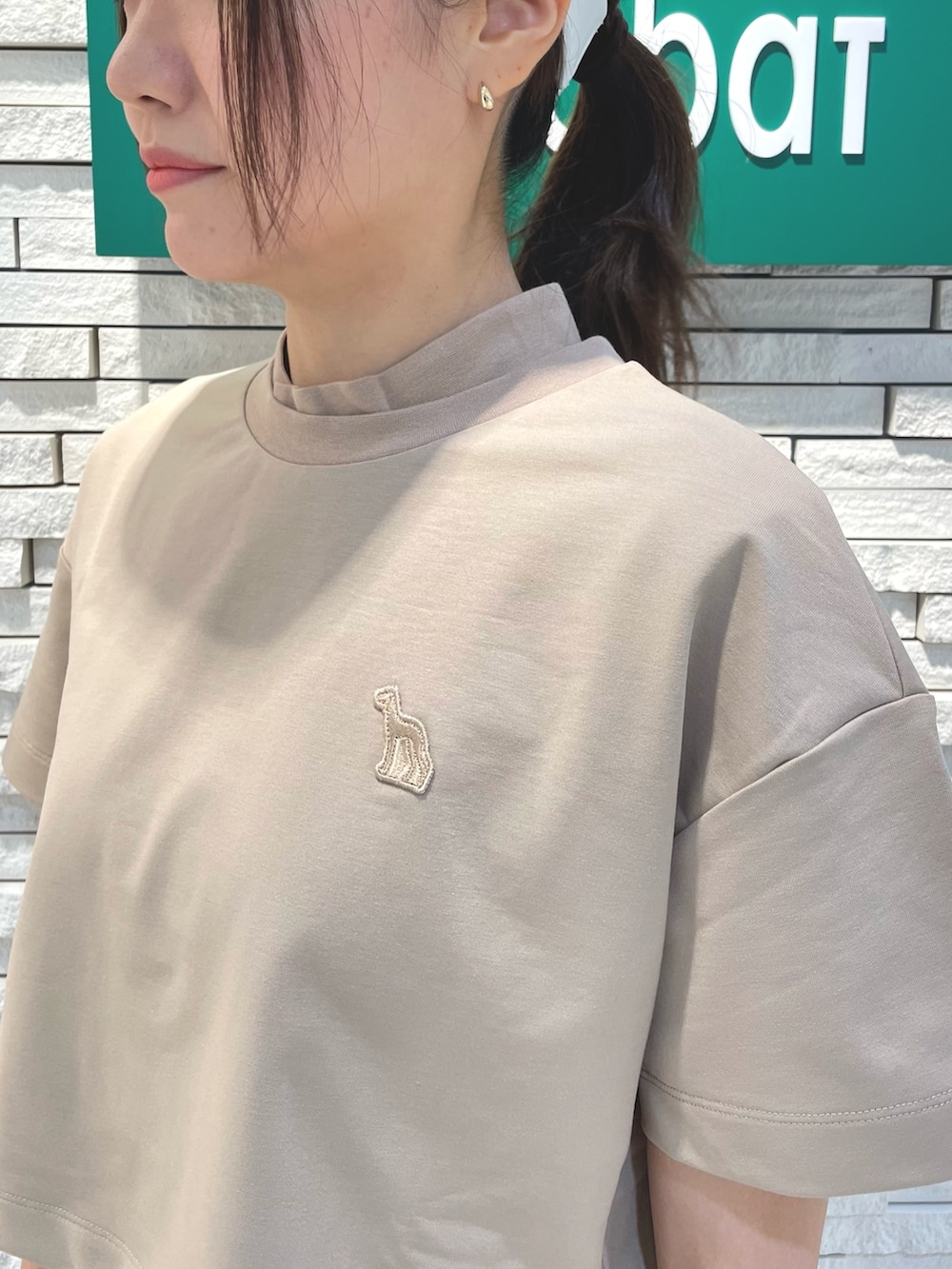 ベージュ系のワンピース、ブルー系のトートバッグ、ホワイト系のサンバイザーを着用したレディースの夏コーディネートの3枚目の写真