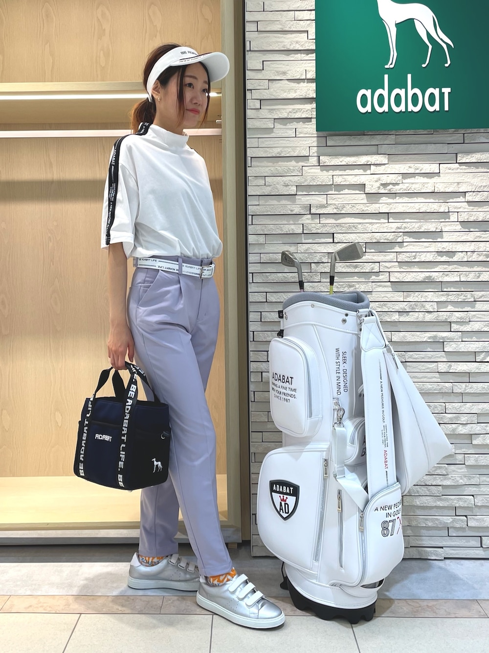 ブルー系のトートバッグ、パープル系のその他パンツ、ホワイト系のTシャツ/カットソーを着用したレディースの夏コーディネートの2枚目の写真