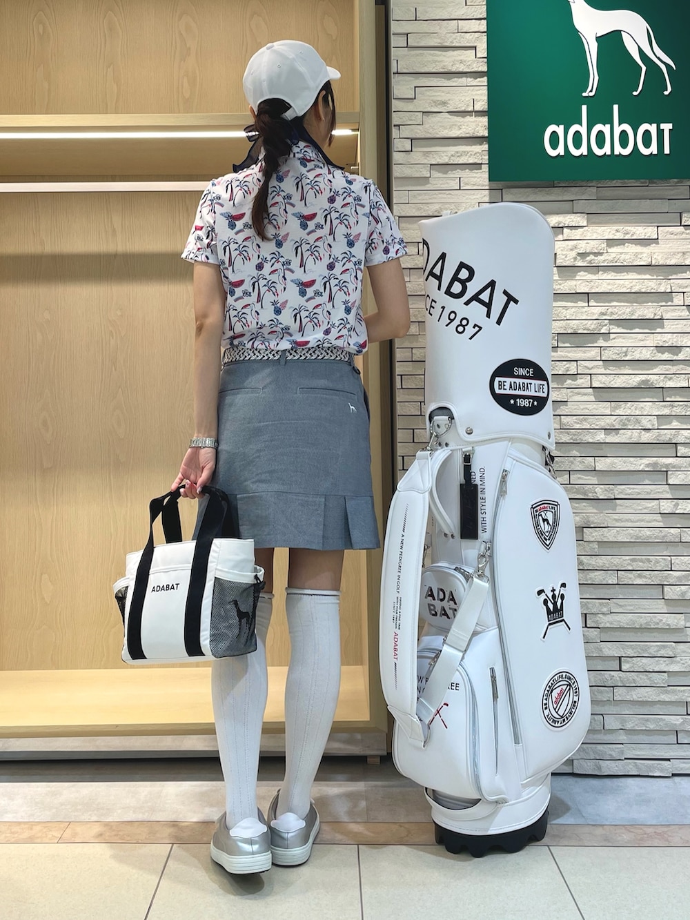 ピンク系のシャツ/ブラウス、ブルー系のスカート、ホワイト系のトートバッグを着用したレディースの夏コーディネートの2枚目の写真