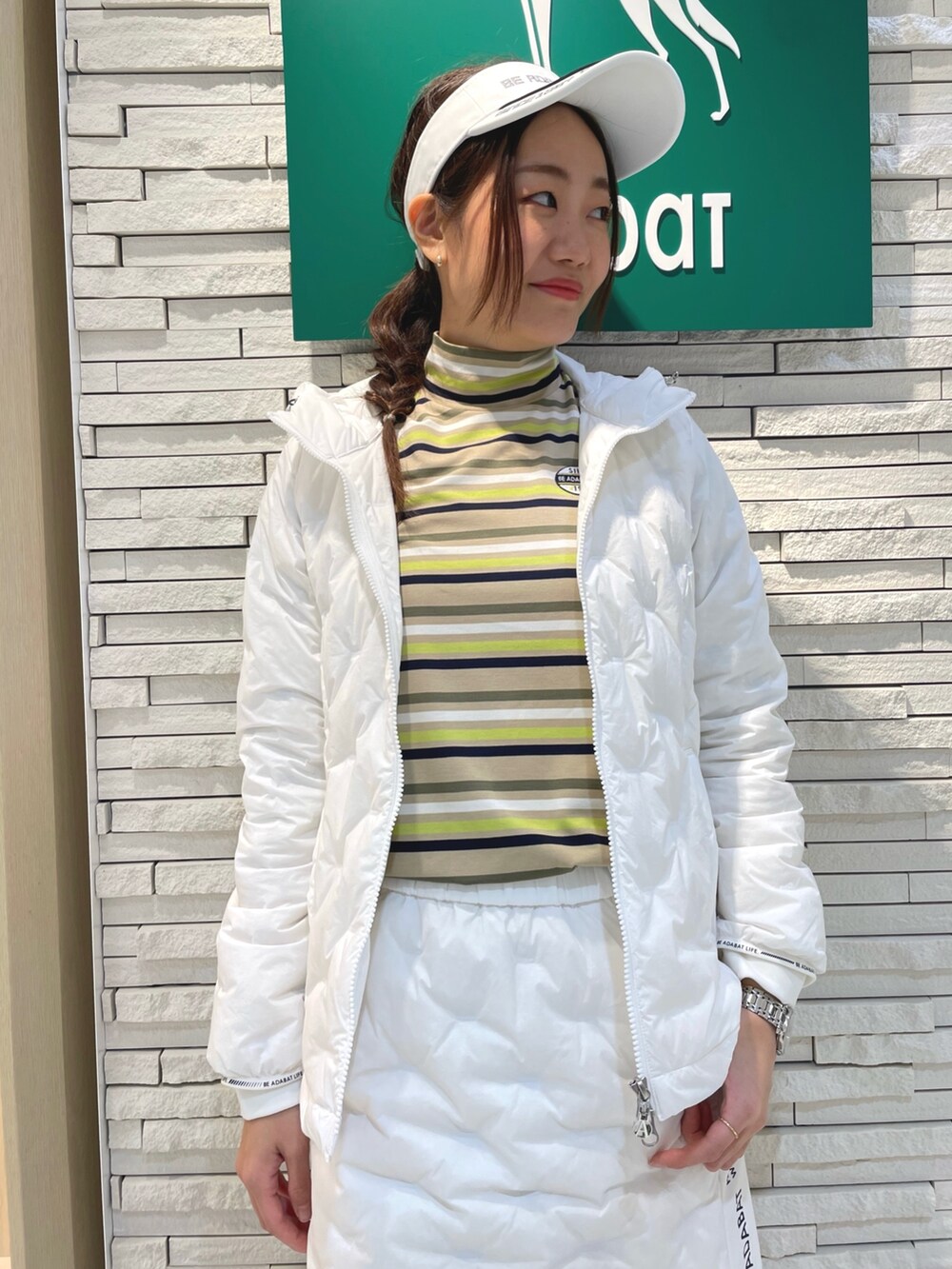 ホワイト系のダウンジャケット/コート、ホワイト系のスカート、グリーン系のトートバッグを着用したレディースの冬コーディネートの4枚目の写真