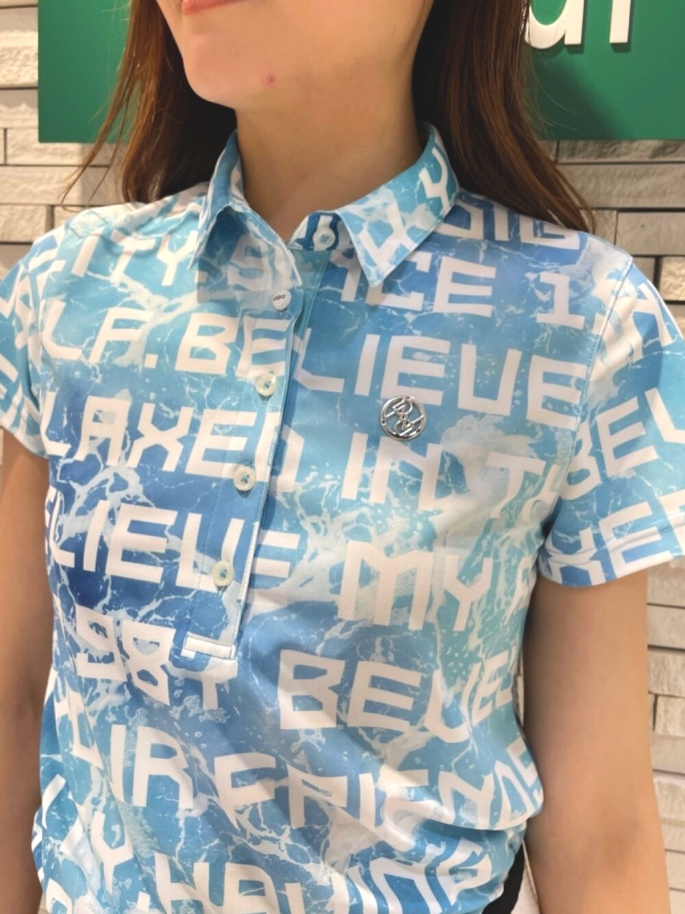 ブルー系のポロシャツ、ホワイト系のスカート、ブルー系のトートバッグを着用したレディースの夏コーディネートの4枚目の写真