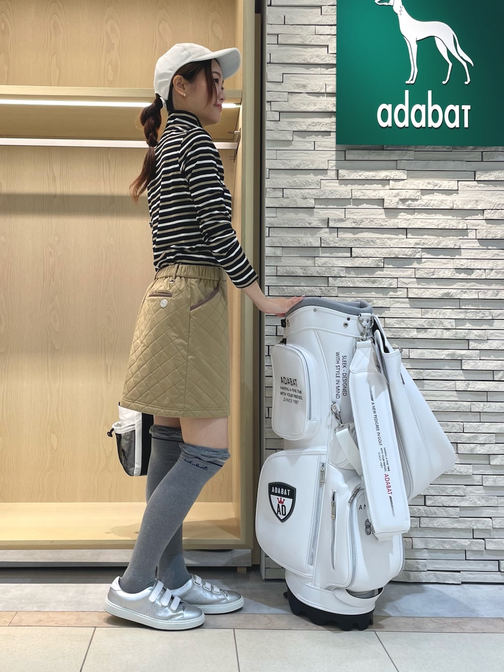 ブルー系のTシャツ/カットソー、イエロー系のスカート、ホワイト系のキャップを着用したレディースの冬コーディネートの2枚目の写真