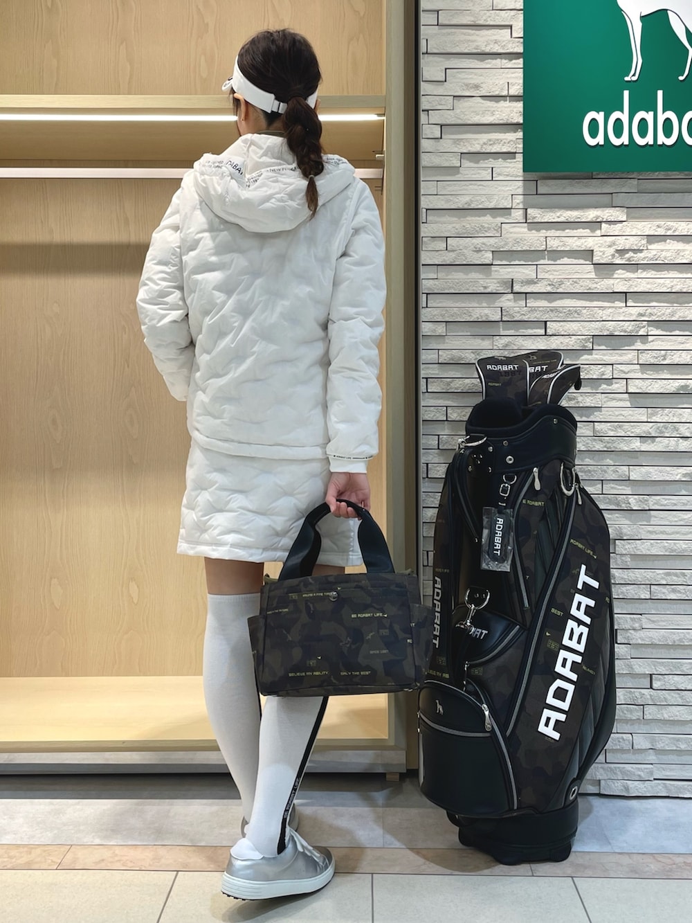 ホワイト系のダウンジャケット/コート、ホワイト系のスカート、グリーン系のトートバッグを着用したレディースの冬コーディネートの3枚目の写真